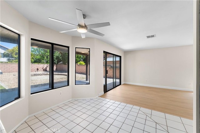 empty room with a ceiling fan, light tile patterned flooring, and baseboards