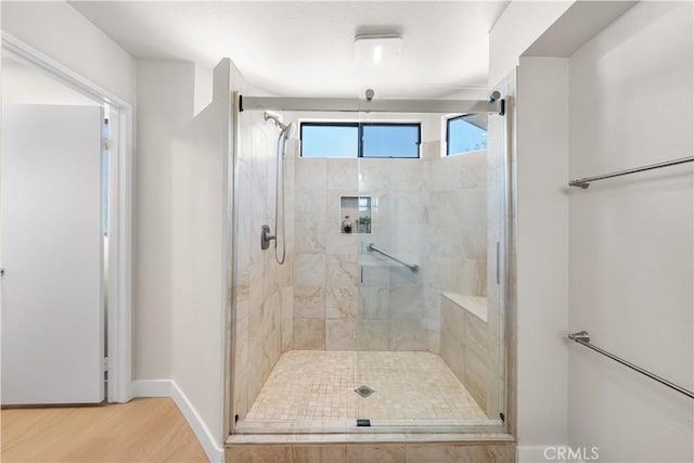 bathroom featuring a stall shower, wood finished floors, and baseboards