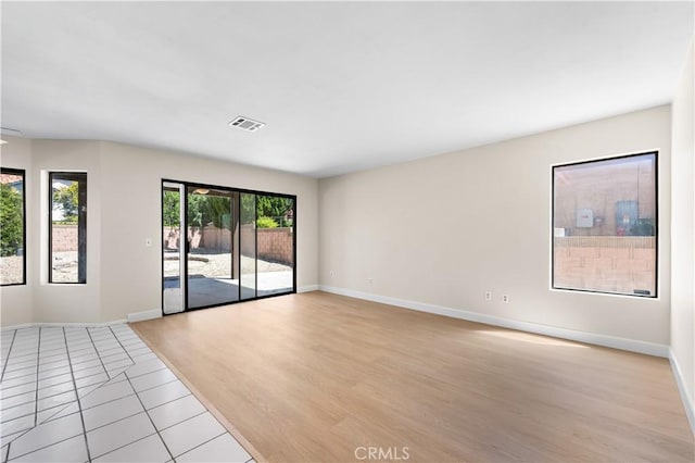 spare room with baseboards and light tile patterned floors