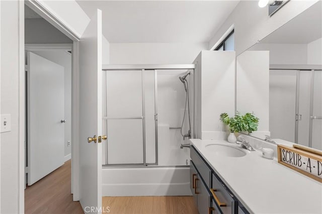 full bathroom with vanity, wood finished floors, and combined bath / shower with glass door
