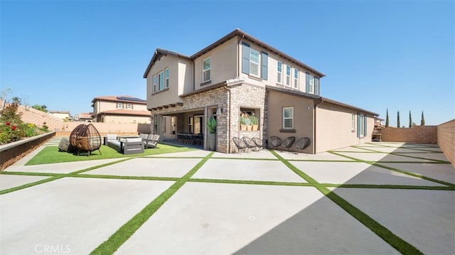 8798 Justify Dr, Rancho Cucamonga, CA 91701 - back of property featuring stone siding, stucco siding, a patio area, and a fenced backyard