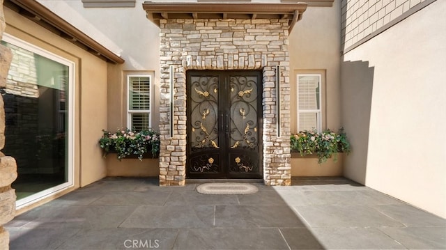 8798 Justify Dr, Rancho Cucamonga, CA 91701 - property entrance featuring french doors, stucco siding, and stone siding