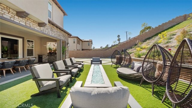 8798 Justify Dr, Rancho Cucamonga, CA 91701 - view of patio featuring outdoor lounge area, a fenced backyard, and exterior kitchen