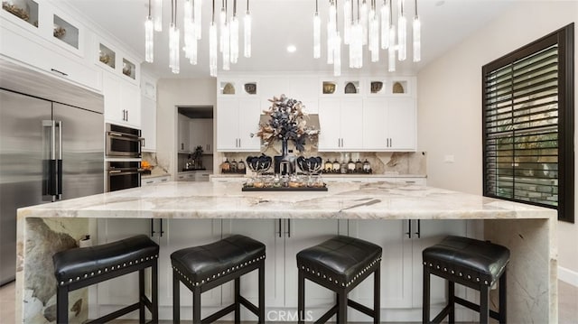 8798 Justify Dr, Rancho Cucamonga, CA 91701 - kitchen with appliances with stainless steel finishes, a chandelier, backsplash, and a large island