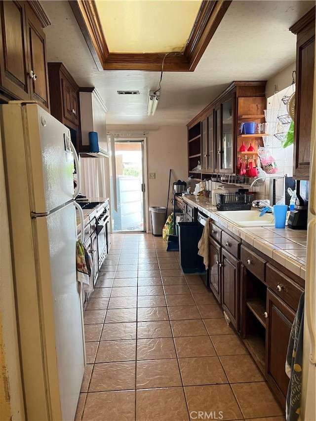 9846 Tamarind Ave, Bloomington, CA 92316 - kitchen with open shelves, freestanding refrigerator, tile countertops, a tray ceiling, and dark brown cabinets
