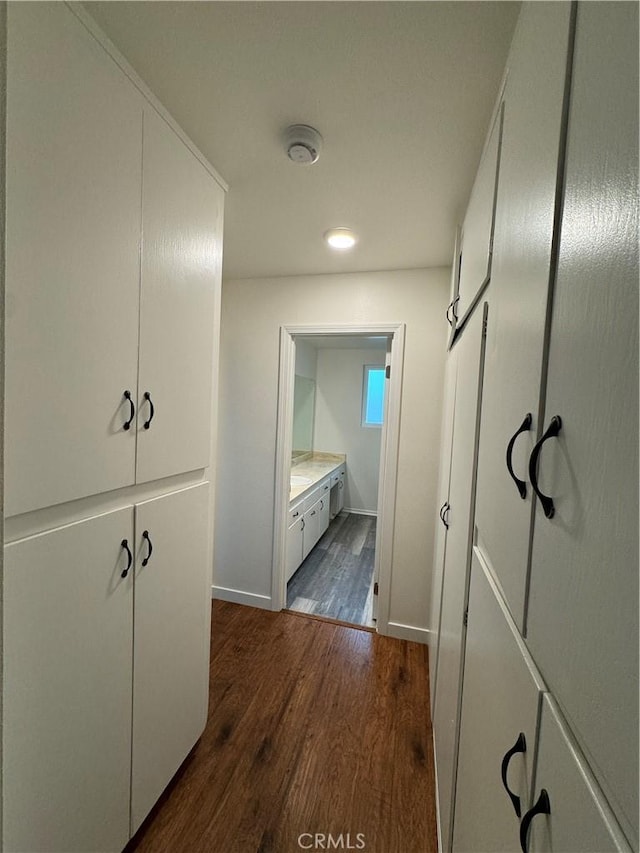 hallway with dark wood-style floors and baseboards