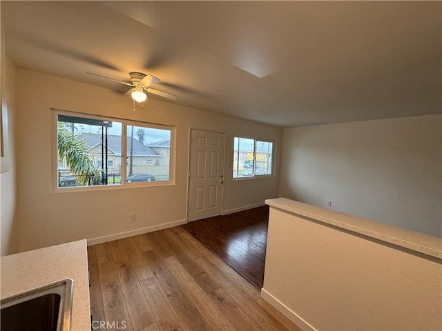 entryway featuring light wood finished floors, baseboards, and ceiling fan