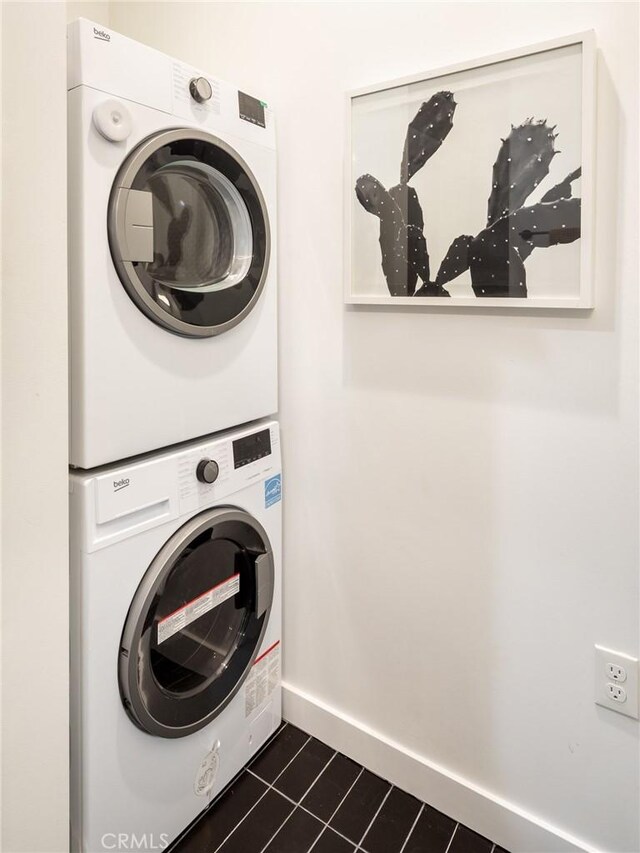 1375 Fortuna Ave, Landers, CA 92285 - laundry area with stacked washing machine and dryer, dark tile patterned floors, and baseboards