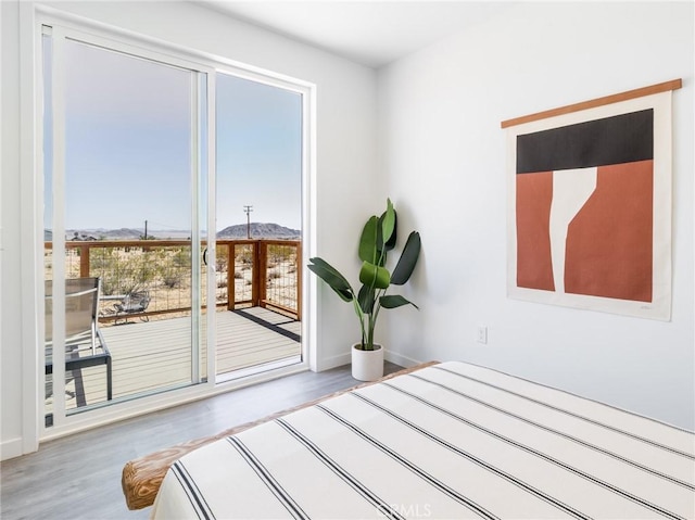 1375 Fortuna Ave, Landers, CA 92285 - unfurnished bedroom with a mountain view, wood finished floors, access to exterior, and baseboards