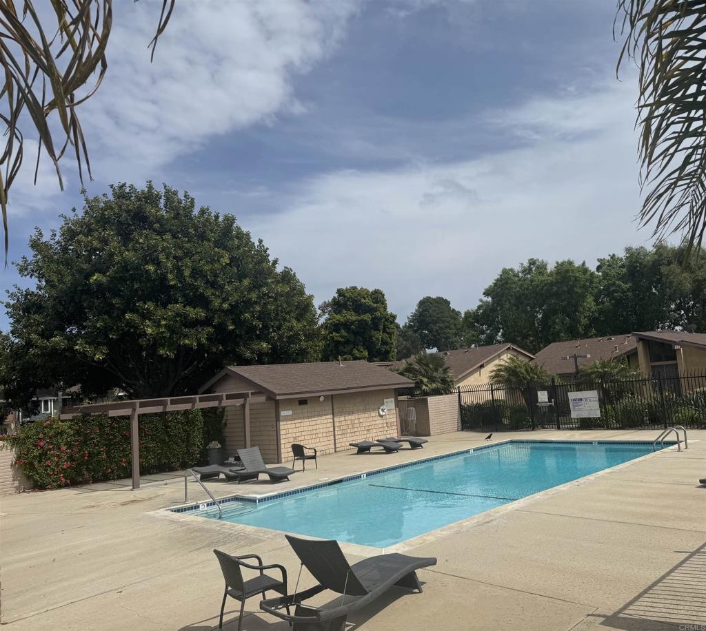 community pool with fence and a patio area