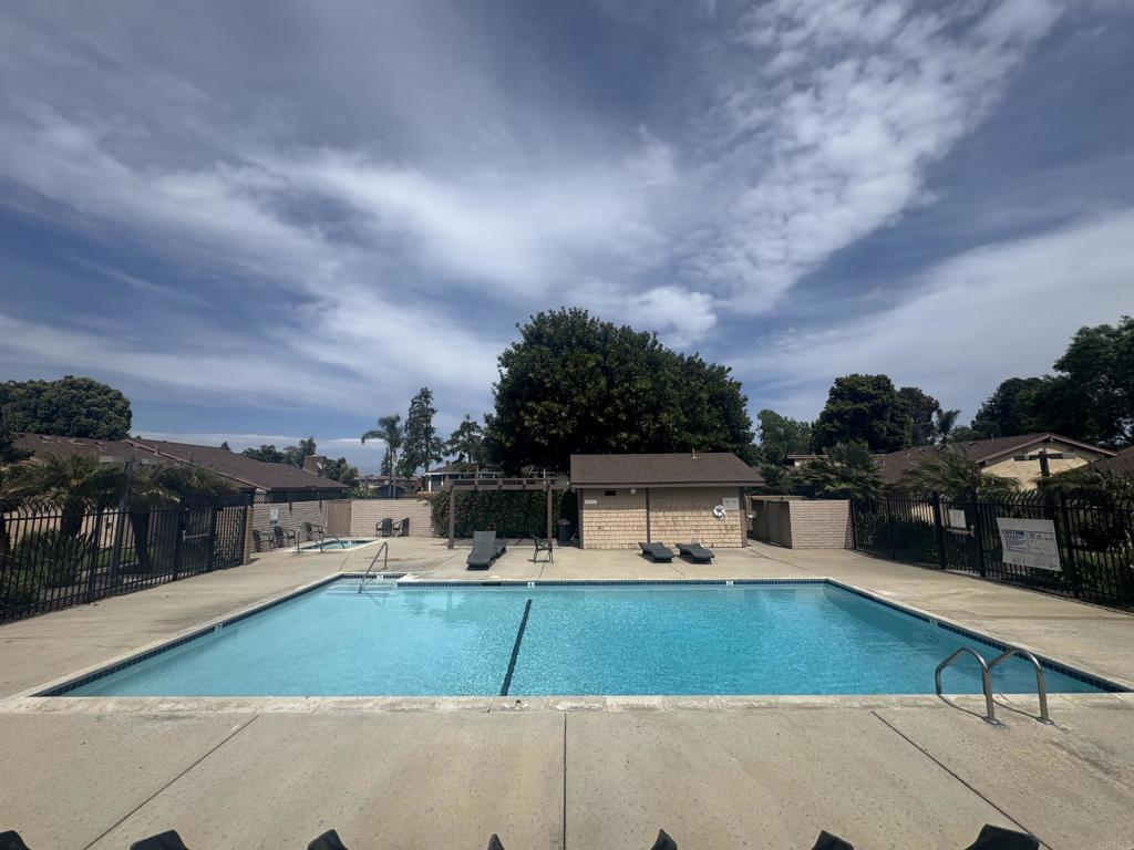 community pool with fence and a patio area