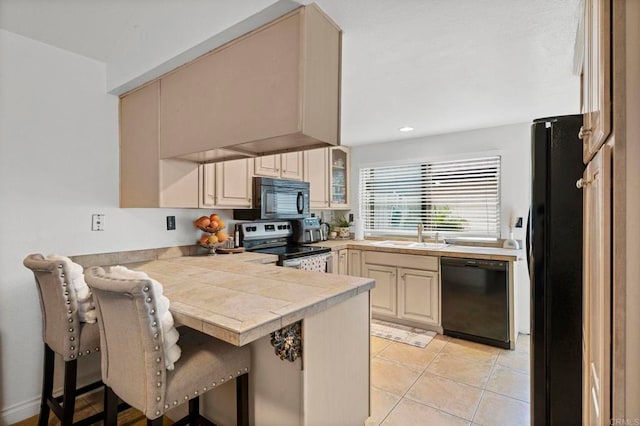 3470 Peach Tree Way, Oceanside, CA 92058 - kitchen featuring black appliances, a peninsula, a sink, a breakfast bar area, and glass insert cabinets
