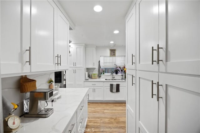 1118 Kwis Ave, Hacienda Heights, CA 91745 - kitchen featuring a sink, white cabinets, recessed lighting, light wood-style flooring, and light stone counters