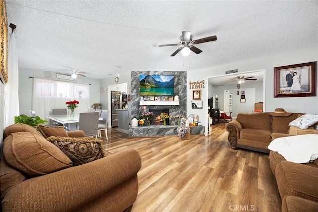 1118 Kwis Ave, Hacienda Heights, CA 91745 - living room featuring a ceiling fan, wood finished floors, a textured ceiling, and a stone fireplace