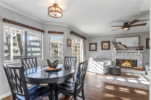 33693 Cattle Creek Rd, Acton, CA 93510 - dining space featuring wood finished floors, a ceiling fan, crown molding, a fireplace, and a textured ceiling