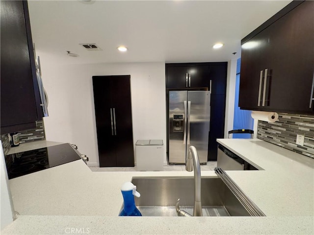 1310 E Ocean Blvd Unit 101, Long Beach, CA 90802 - kitchen featuring stainless steel fridge with ice dispenser, a sink, light countertops, decorative backsplash, and recessed lighting
