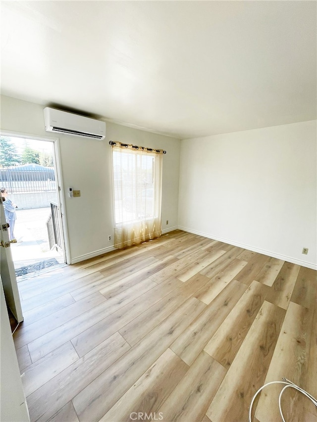 1330 S Reservoir St, Pomona, CA 91766 - spare room featuring a wall mounted air conditioner, light wood-style floors, and baseboards