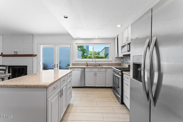 1805 Adelaide Ct, Oxnard, CA 93035 - kitchen with appliances with stainless steel finishes, a sink, light stone countertops, a center island, and recessed lighting