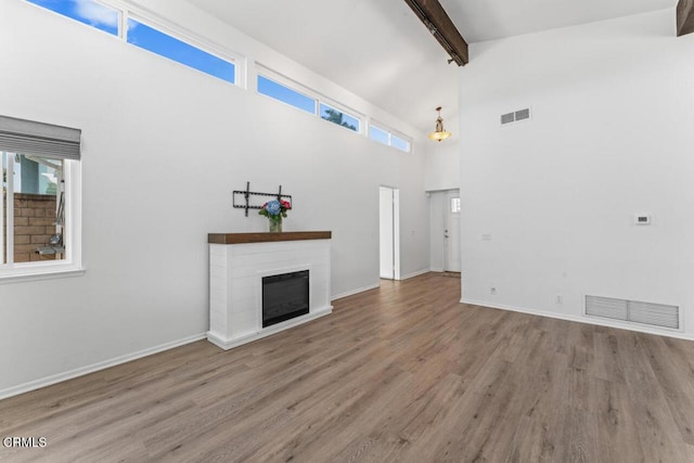 1805 Adelaide Ct, Oxnard, CA 93035 - unfurnished living room featuring beamed ceiling, wood finished floors, high vaulted ceiling, a glass covered fireplace, and baseboards
