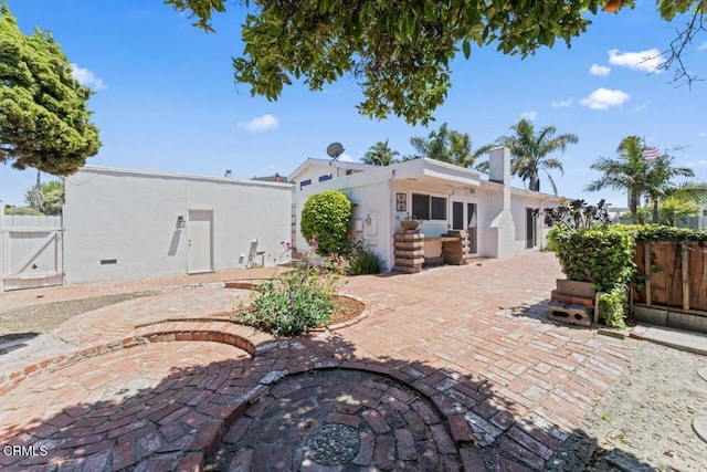 1805 Adelaide Ct, Oxnard, CA 93035 - rear view of house with a patio area, stucco siding, a gate, fence, and a chimney