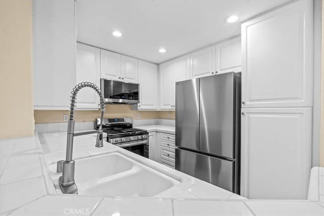 1 Firenze Ct, Newport Coast, CA 92657 - kitchen with stainless steel appliances, white cabinets, recessed lighting, and tile countertops