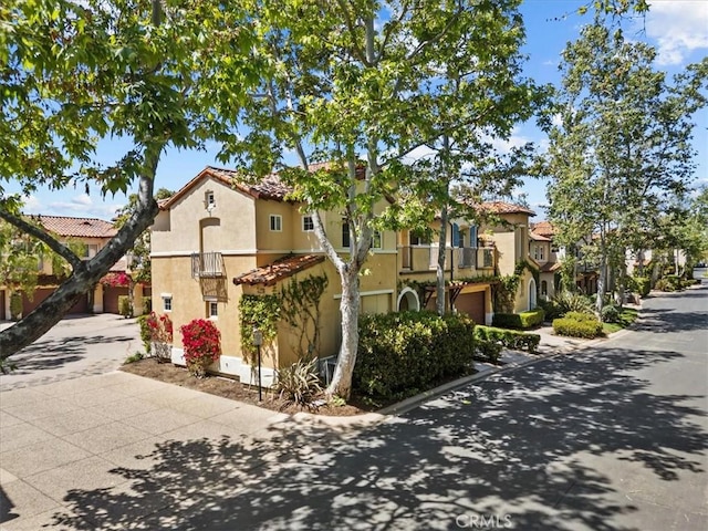 1 Firenze Ct, Newport Coast, CA 92657 - view of front of home featuring stucco siding, a tile roof, a balcony, an attached garage, and driveway