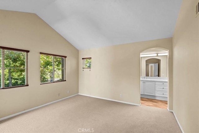 1 Firenze Ct, Newport Coast, CA 92657 - empty room featuring light carpet, vaulted ceiling, baseboards, and a sink