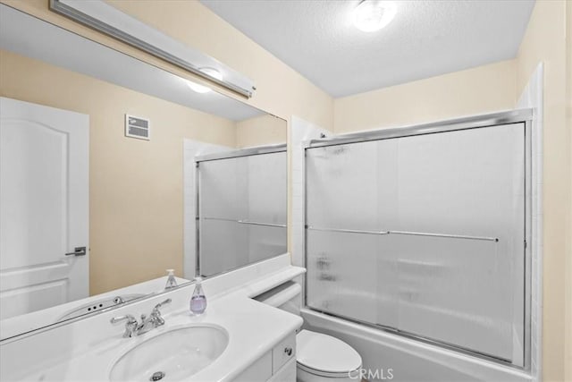 1 Firenze Ct, Newport Coast, CA 92657 - bathroom featuring vanity, toilet, a textured ceiling, and shower / bath combination with glass door