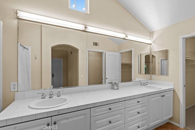 1 Firenze Ct, Newport Coast, CA 92657 - bathroom featuring double vanity, vaulted ceiling, tile patterned floors, and a spacious closet