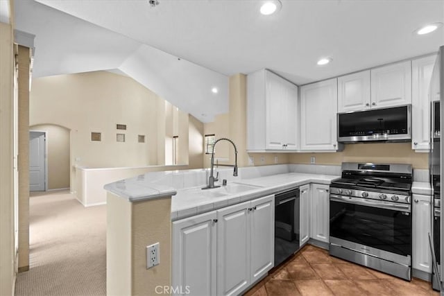 1 Firenze Ct, Newport Coast, CA 92657 - kitchen featuring appliances with stainless steel finishes, a sink, a peninsula, white cabinets, and lofted ceiling
