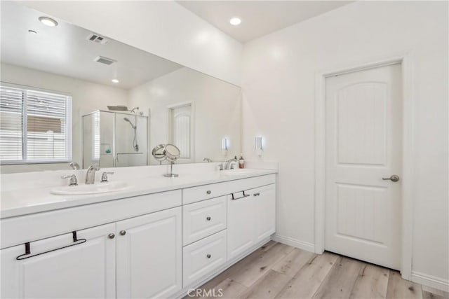 29167 Moraga St, Menifee, CA 92584 - bathroom with a stall shower, wood finished floors, double vanity, recessed lighting, and baseboards