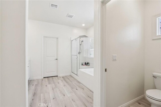 29167 Moraga St, Menifee, CA 92584 - bathroom featuring an enclosed shower, wood finished floors, toilet, a bath, and baseboards