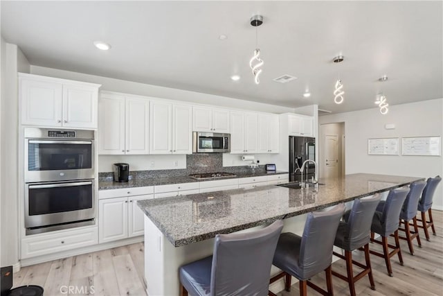 29167 Moraga St, Menifee, CA 92584 - kitchen featuring appliances with stainless steel finishes, a sink, light wood-style flooring, a large island, and recessed lighting