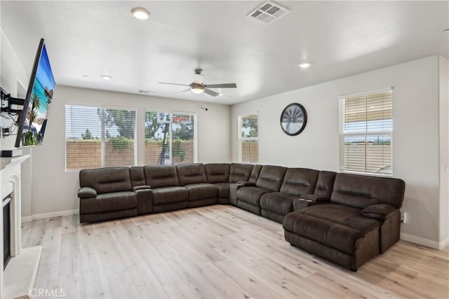 29167 Moraga St, Menifee, CA 92584 - living room featuring light wood-type flooring, ceiling fan, baseboards, recessed lighting, and a fireplace with raised hearth