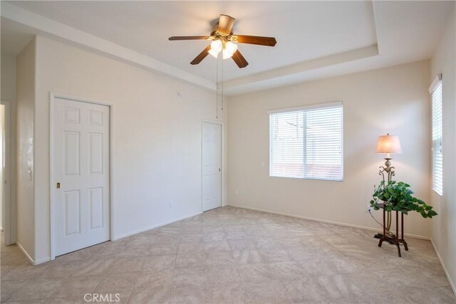 28046 Crystal Spring Dr, Menifee, CA 92584 - spare room with ceiling fan, a tray ceiling, and baseboards
