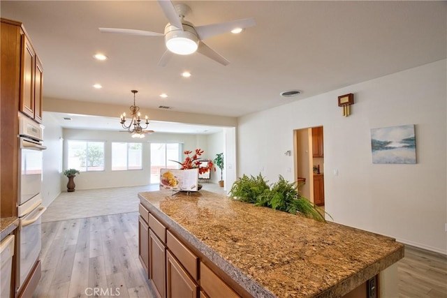 28046 Crystal Spring Dr, Menifee, CA 92584 - kitchen with brown cabinets, open floor plan, light wood-type flooring, a kitchen island, and recessed lighting