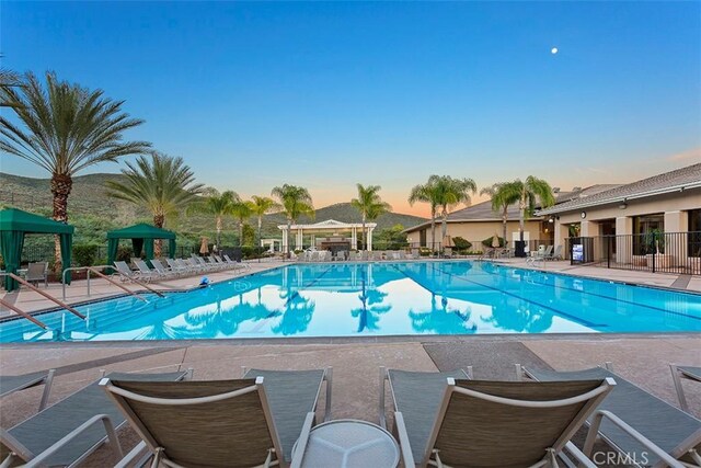 28046 Crystal Spring Dr, Menifee, CA 92584 - pool at dusk featuring a community pool and a patio