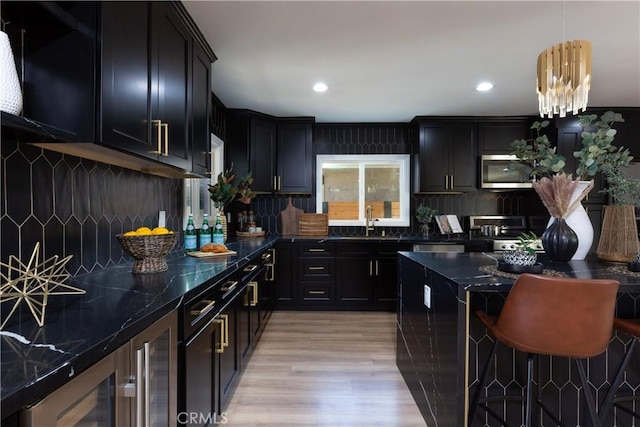 4325 N Country Club Ln, Long Beach, CA 90807 - kitchen featuring stainless steel appliances, dark cabinets, a kitchen breakfast bar, light wood finished floors, and tasteful backsplash