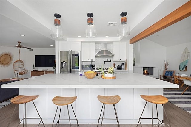 24132 Snipe Ln, Laguna Niguel, CA 92677 - kitchen featuring stainless steel refrigerator with ice dispenser, wall chimney range hood, open floor plan, light wood-type flooring, and recessed lighting