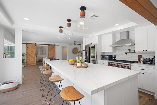24132 Snipe Ln, Laguna Niguel, CA 92677 - kitchen with wall chimney range hood, a raised ceiling, a barn door, stainless steel refrigerator with ice dispenser, and tasteful backsplash