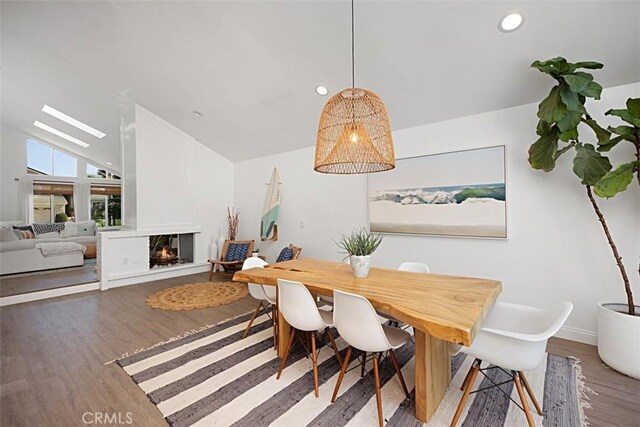 24132 Snipe Ln, Laguna Niguel, CA 92677 - dining space with vaulted ceiling, wood finished floors, a multi sided fireplace, and recessed lighting