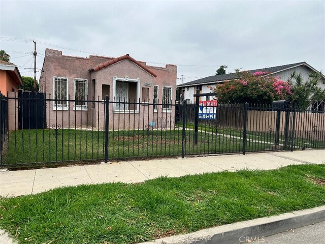 3641 E Elizabeth St, Compton, CA 90221 - mediterranean / spanish house with a fenced front yard, stucco siding, and a tile roof