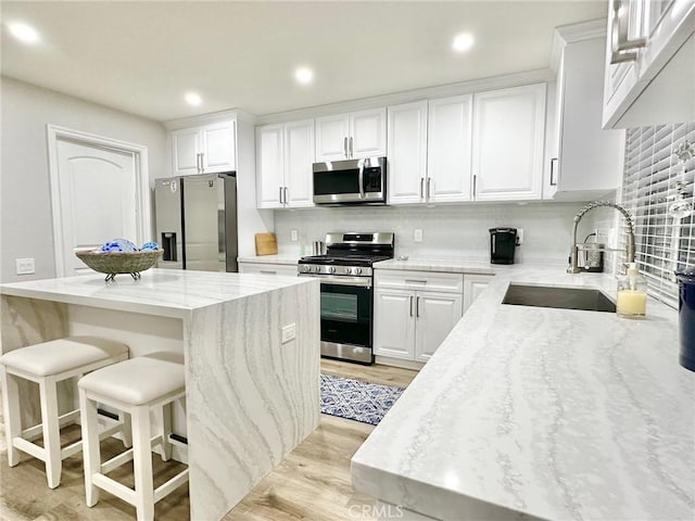24082 Calendula, Mission Viejo, CA 92692 - kitchen featuring appliances with stainless steel finishes, a sink, light wood-type flooring, white cabinetry, and recessed lighting