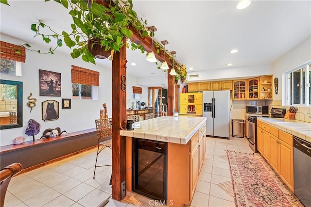 kitchen featuring wine cooler, stainless steel appliances, tile counters, light tile patterned floors, and recessed lighting