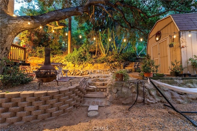 view of patio / terrace featuring a storage unit, an outdoor fire pit, and an outdoor structure