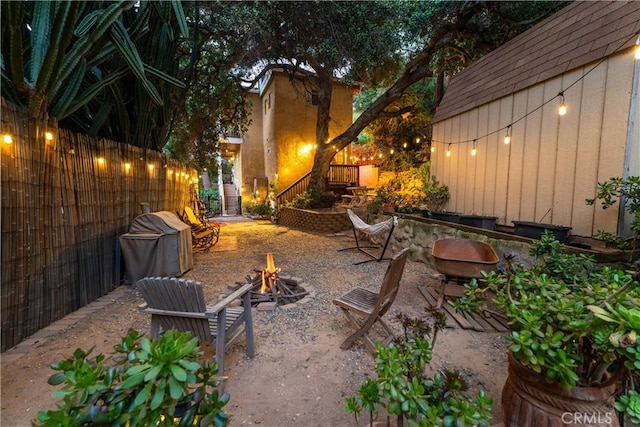 view of patio / terrace with an outdoor fire pit and fence
