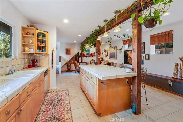 kitchen with tile countertops, a sink, dishwasher, decorative backsplash, and recessed lighting