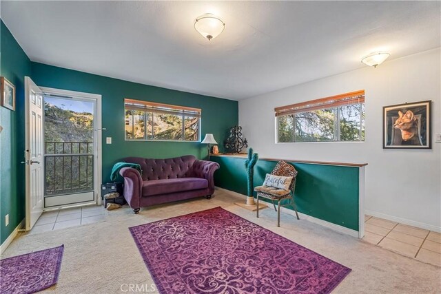 living area with carpet, healthy amount of natural light, and tile patterned flooring