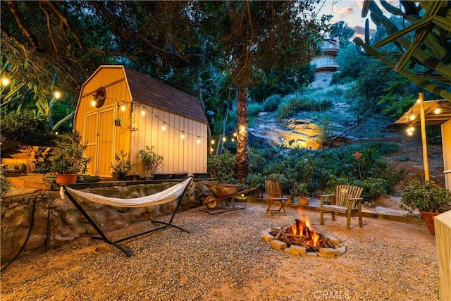 view of yard with an outdoor fire pit, a storage unit, and an outdoor structure