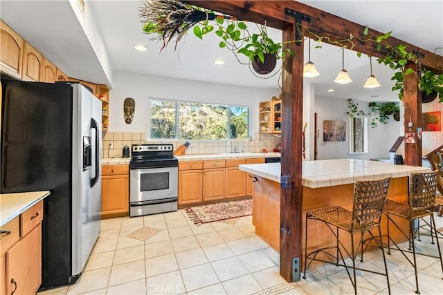 kitchen featuring stainless steel appliances, tile counters, backsplash, a kitchen breakfast bar, and recessed lighting
